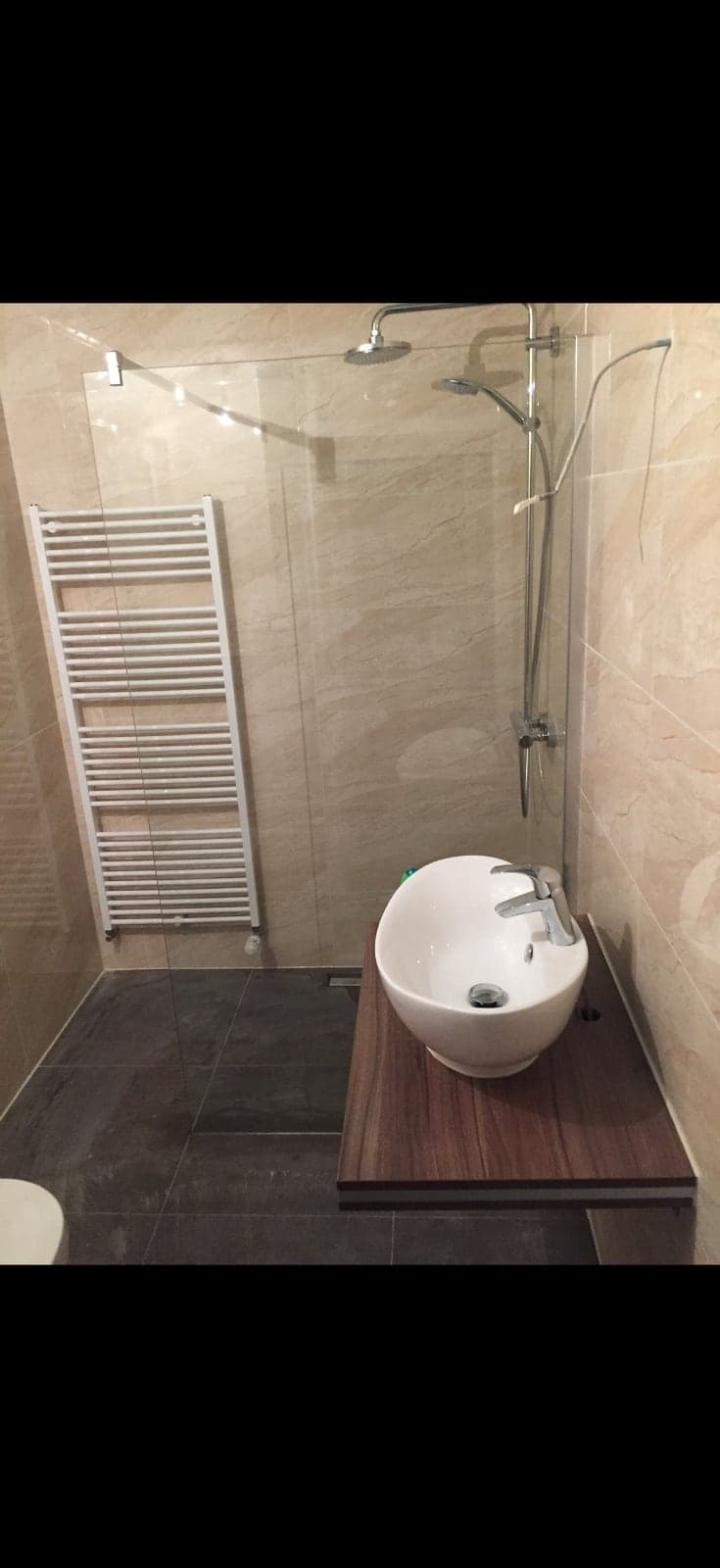 Bodengleiche Dusche mit Marmoroptik-Fliesen und Handtuchheizkörper