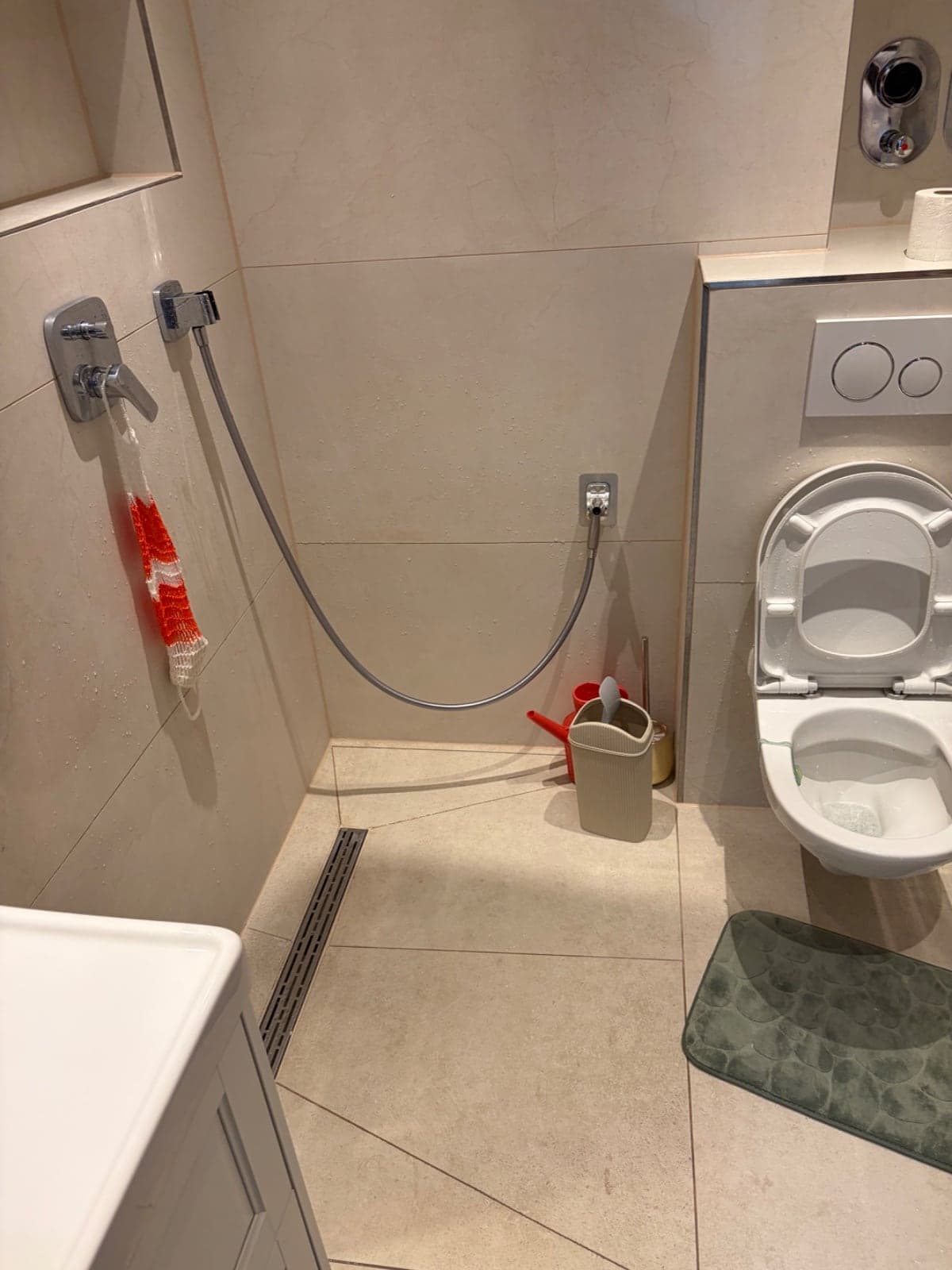Bodengleiche Dusche mit Duschrinne, Handbrause und wandhängendem WC