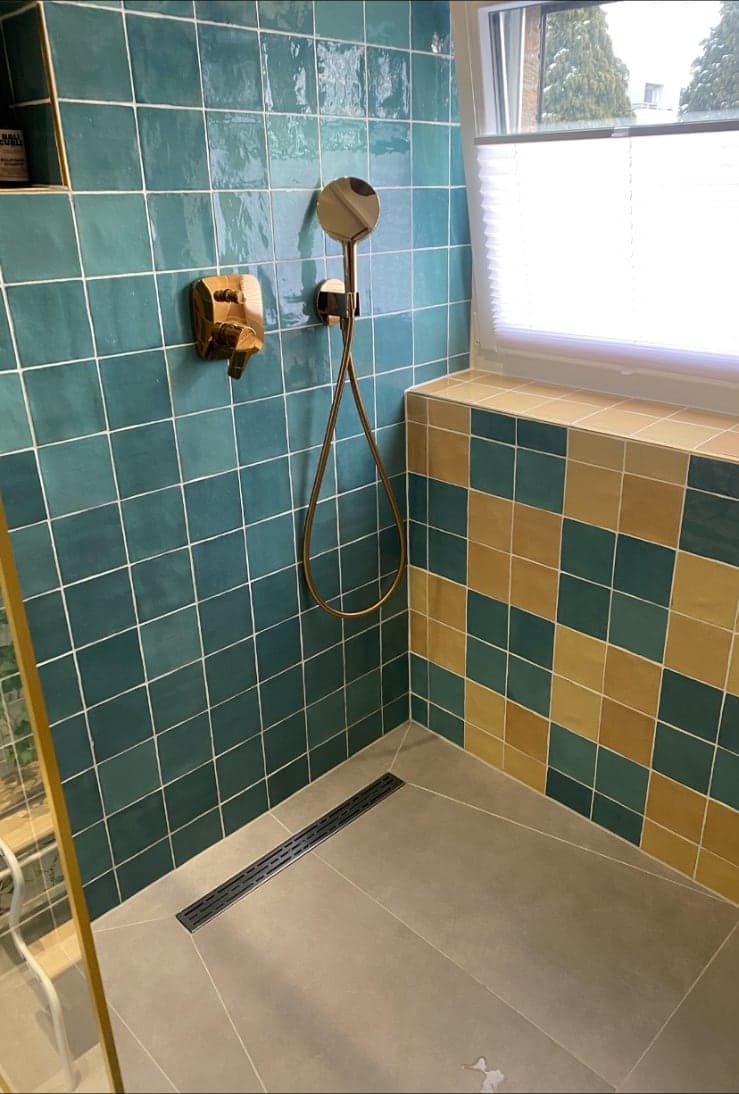 Fertige Dusche mit türkisfarbenen Mosaikfliesen und Karomuster in Gold und Petrol