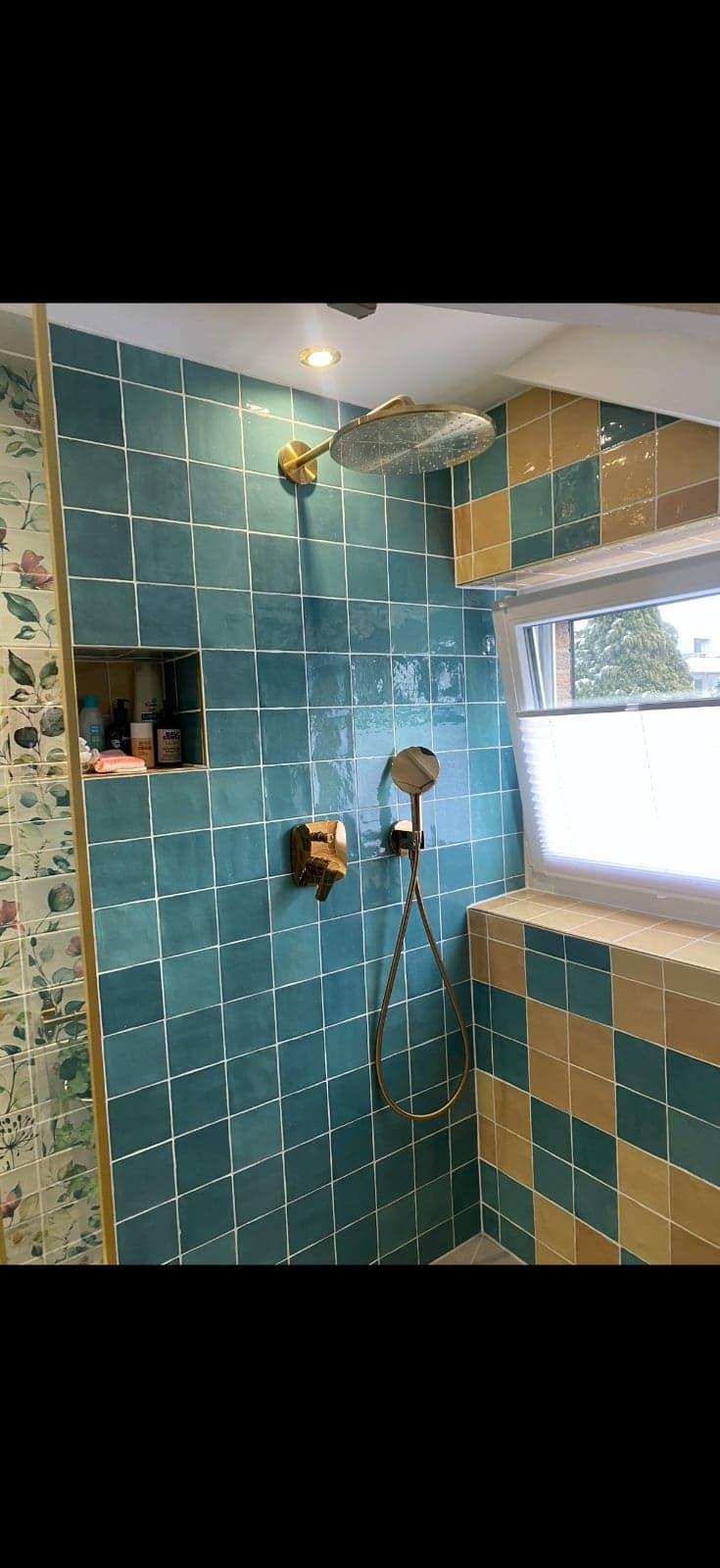 Duschbereich mit Regenbrause und offenem Ablagefach in der Fliesenwand