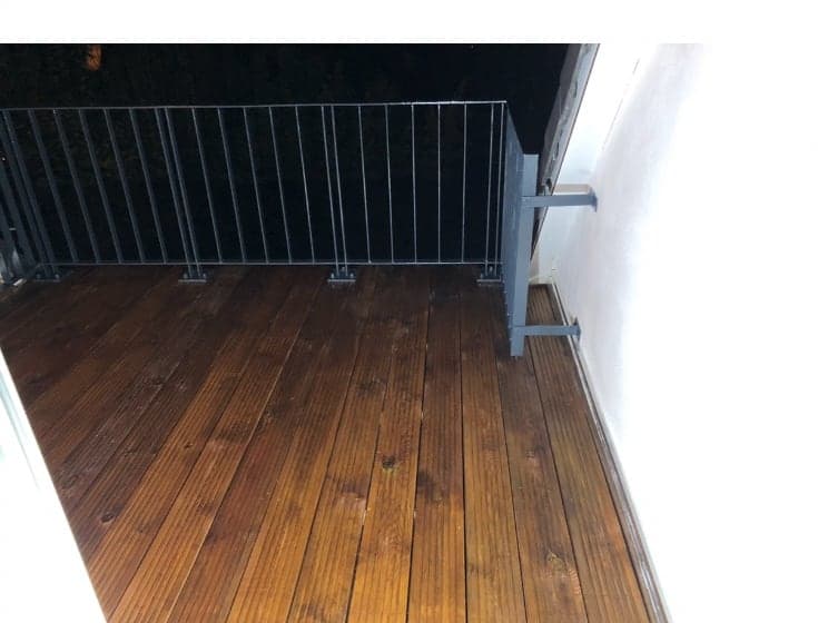 Fertiger Balkon mit verlegtem Holzdielenbelag und Metallgeländer