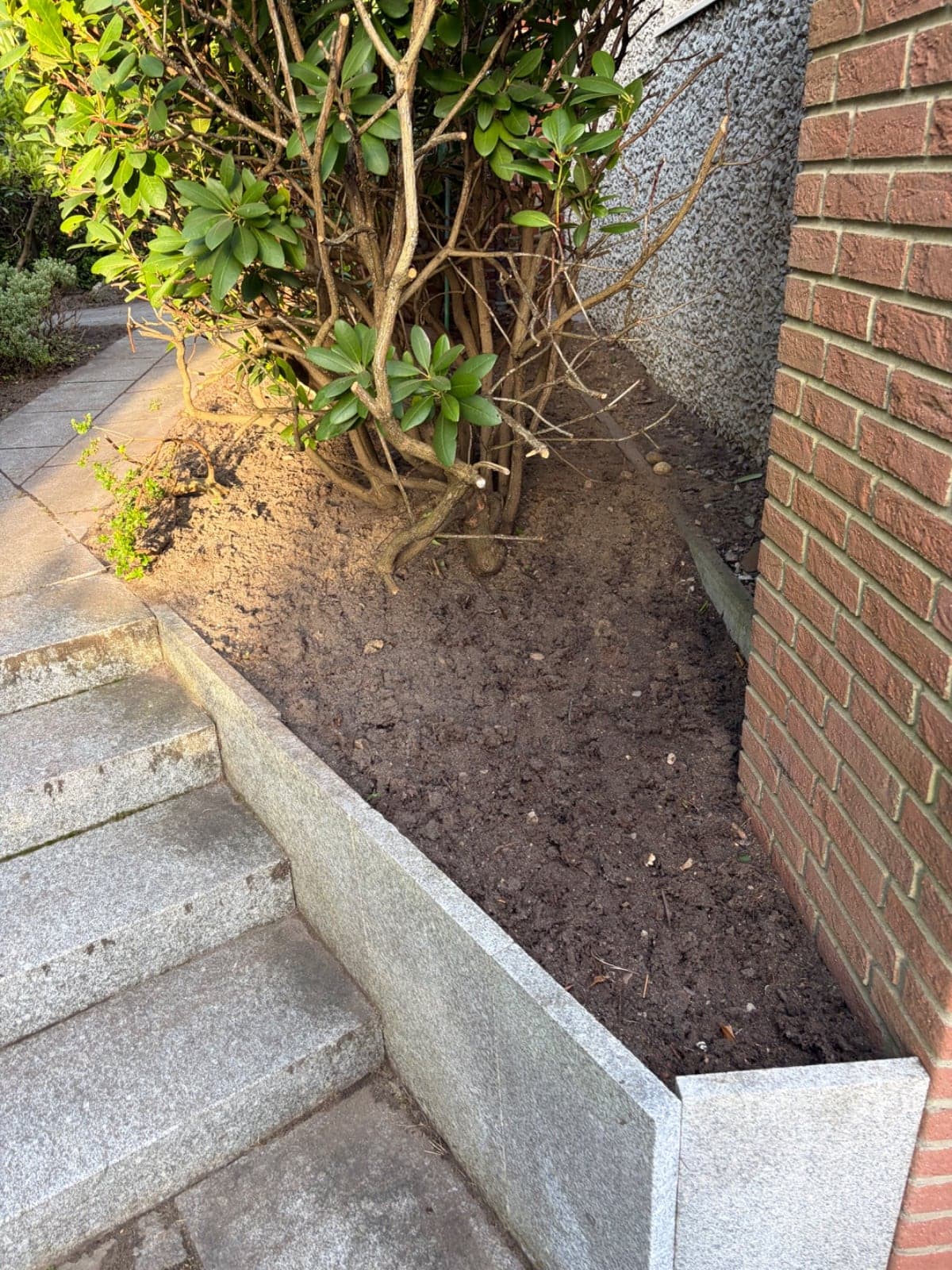 Granitstufen und Beeteinfassung an der Hauswand