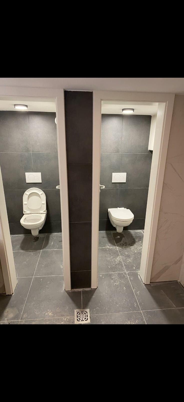 Reihe fertiggestellter WC-Kabinen in einer Gewerbeimmobilie