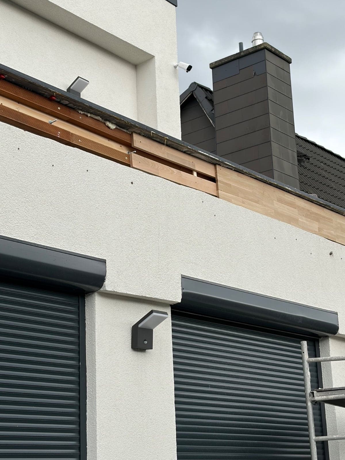 Neue Dachrandverkleidung und frisch verputzte Fassade mit Rollläden