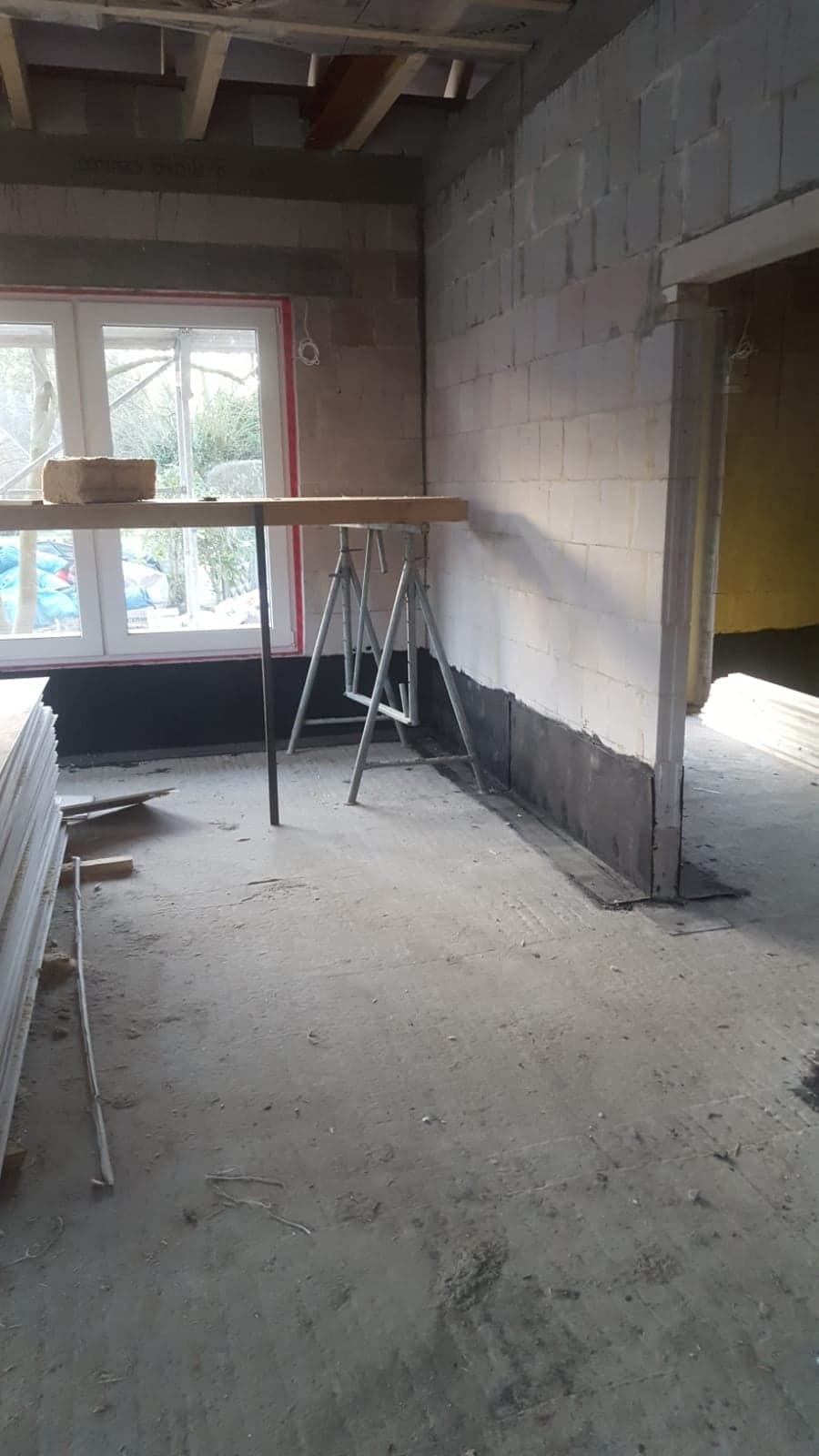 Neu errichtete Kalksandsteinwand mit Sockelabdichtung