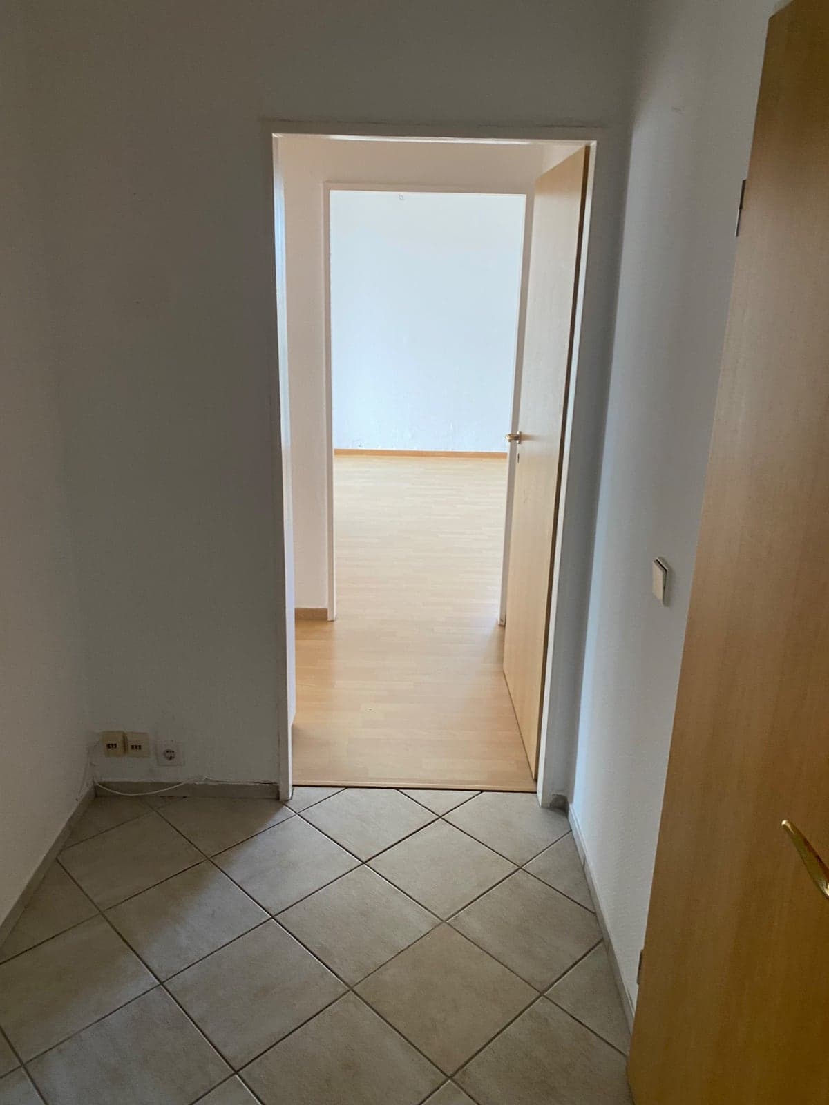 Flur mit Übergang von Fliesen zu neuem Laminatboden